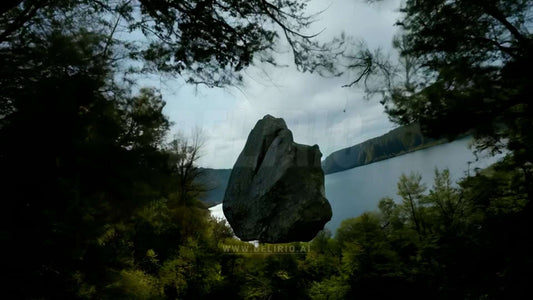 A cinematic shot of a giant stone floating above a river in a forest, with smooth camera movement enhancing the scene.