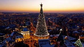 A picturesque sunset view over a city, with holiday decorations adorning the streets and the Christmas spirit filling the air.