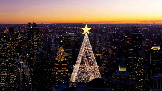 A breathtaking aerial view of a city at sunset, showcasing the dazzling Christmas tree lights against the backdrop of the setting sun.