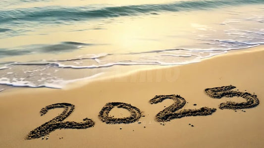 """2025"" written in sand, just beyond ocean waves, a simple yet striking beachside New Year�s message."