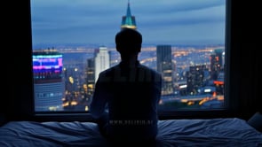 Rear View of a Man Looking Through Window At Modern City Skyscrapers