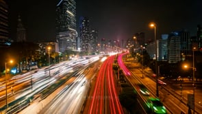 Urban highway at night in a lit time-lapse, expressing the rhythm and movement of city life.