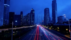 Wide-angle view of a modern city skyline captured in a time-lapse, showcasing the vibrant energy of a bustling metropolis with illuminated buildings and dynamic light trails.