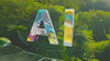 AI letters with a reflective texture floating against a natural forest background, symbolizing nature-tech fusion.